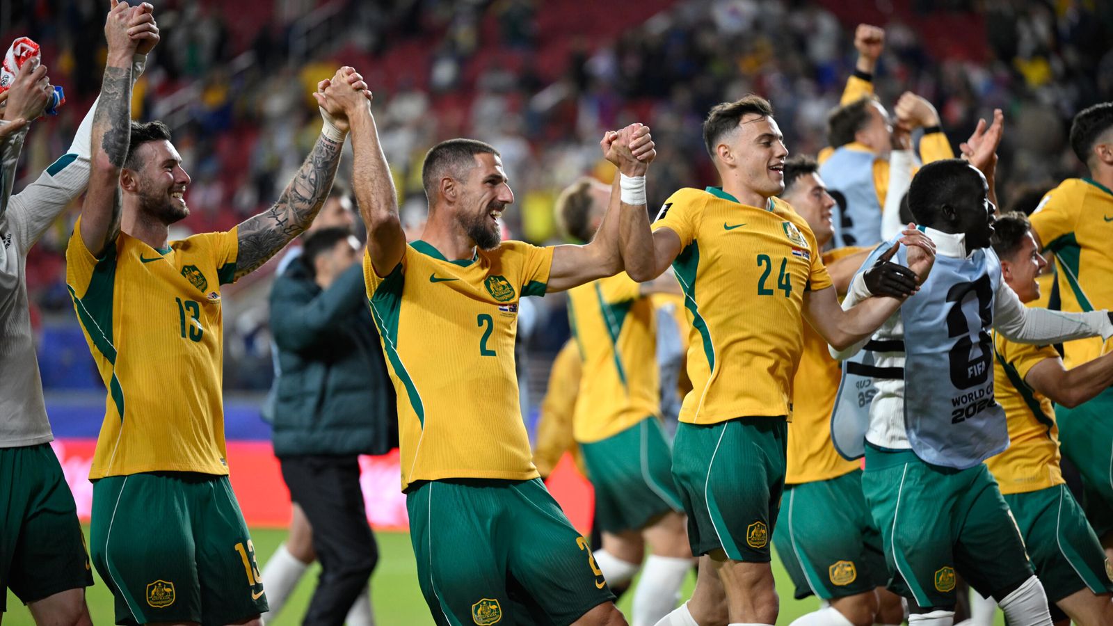 Australia players celebrate in their gold and green kit after the goalless draw with Paraguay sealed their place in the 2026 World Cup Round of 32.