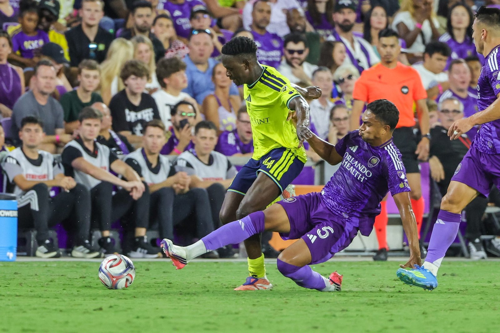 Nashville SC midfielder shields the ball from an Orlando City defender at Inter&Co Stadium