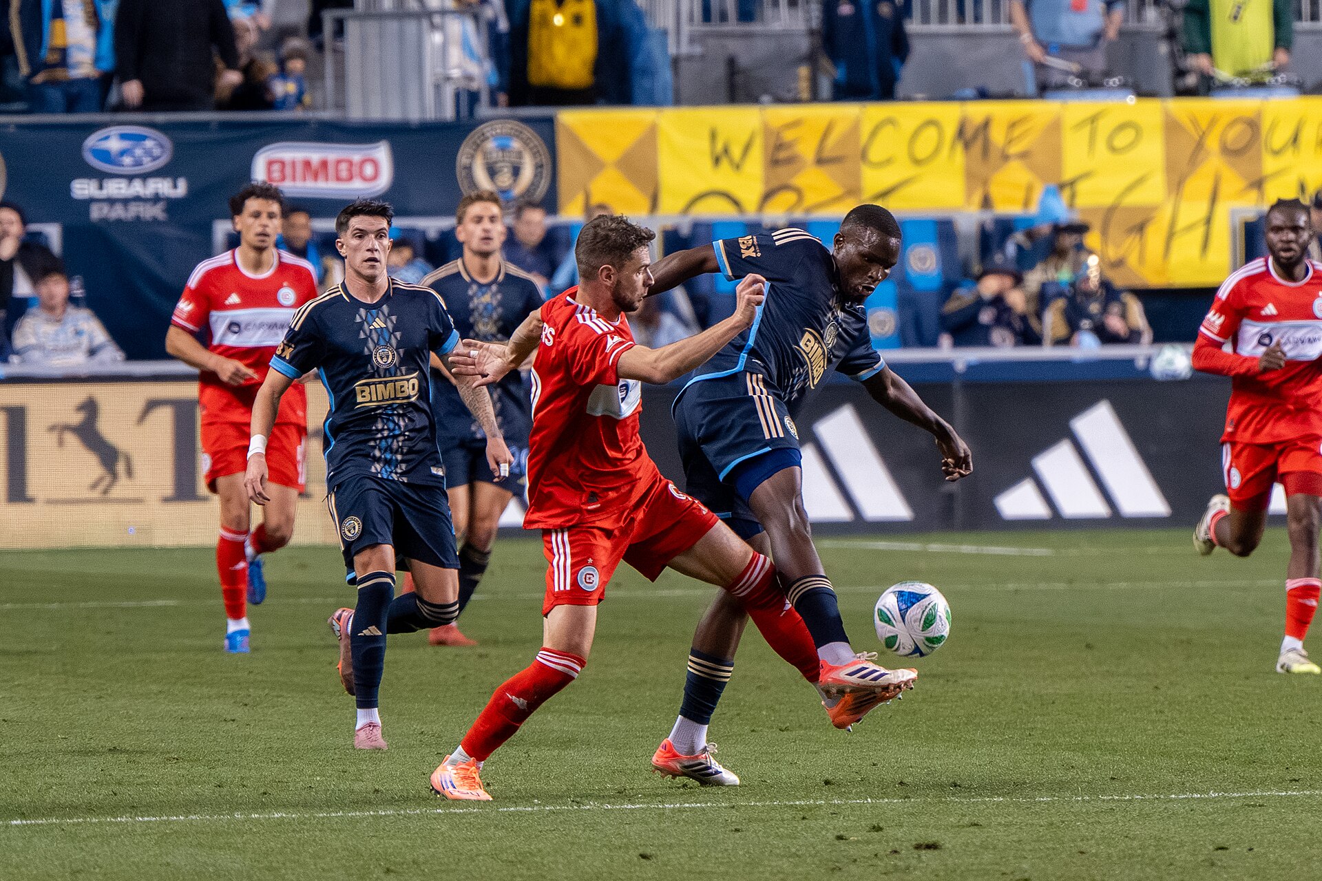 Hugo Cuypers in Chicago Fire red kit chases a Philadelphia Union defender during an MLS match
