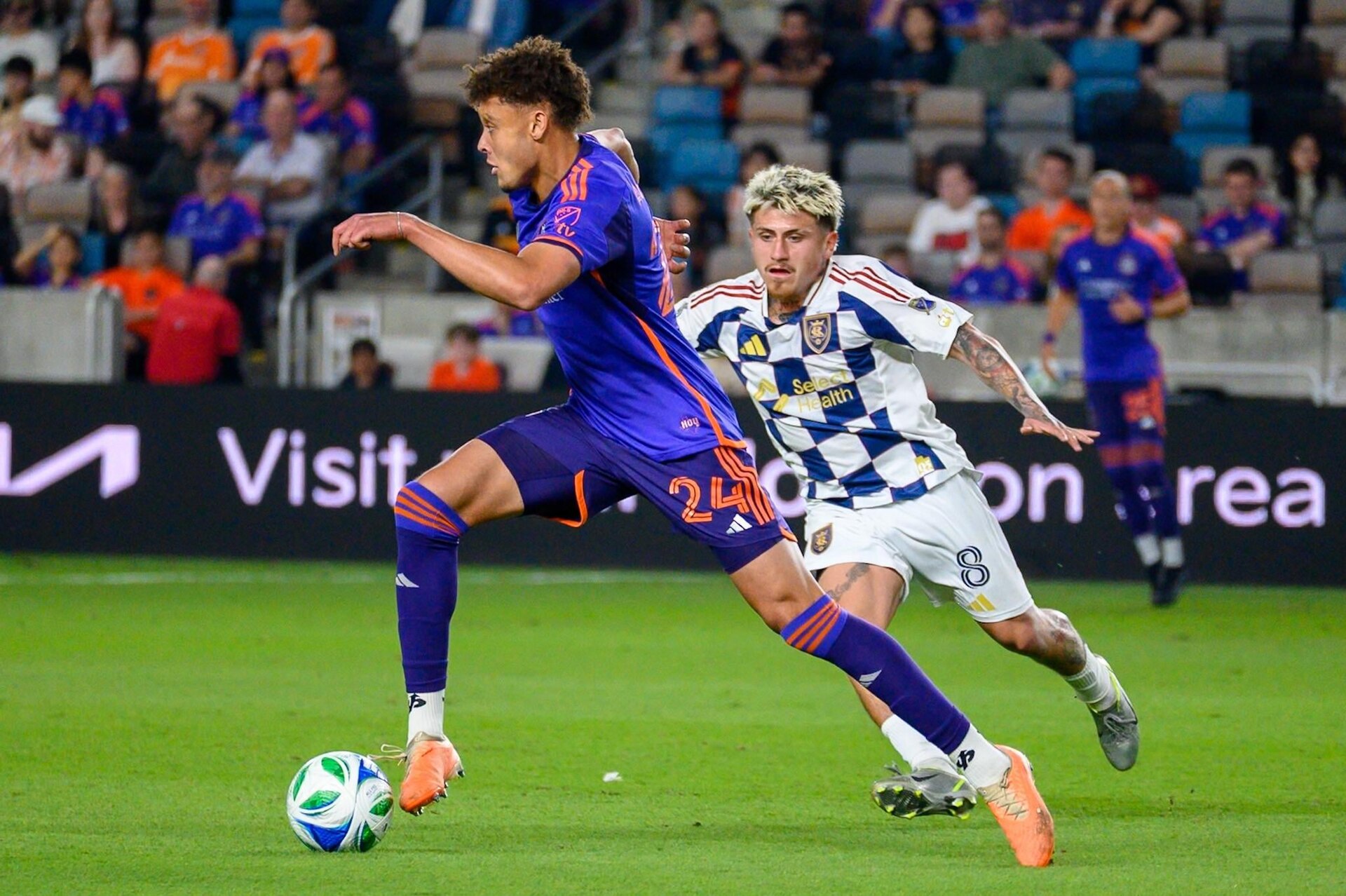 Real Salt Lake midfielder in the checkerboard away kit closes down a Houston Dynamo player