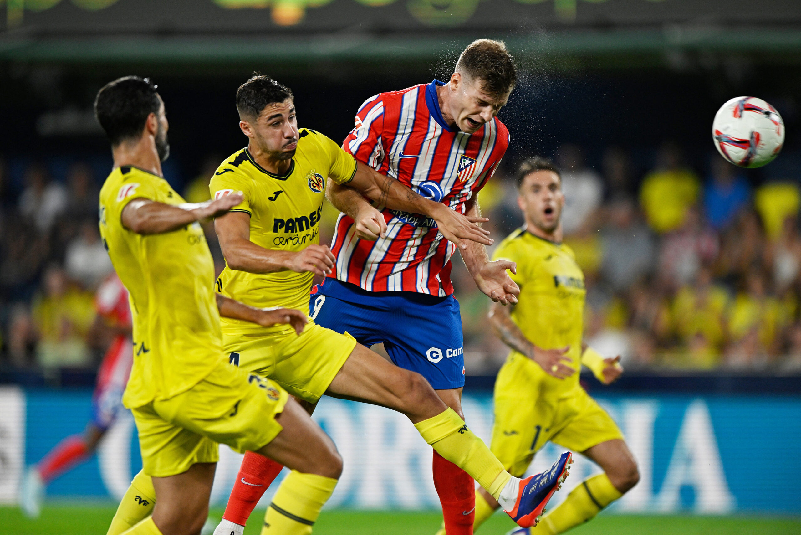 Atletico Madrid and Villarreal players challenge for a header